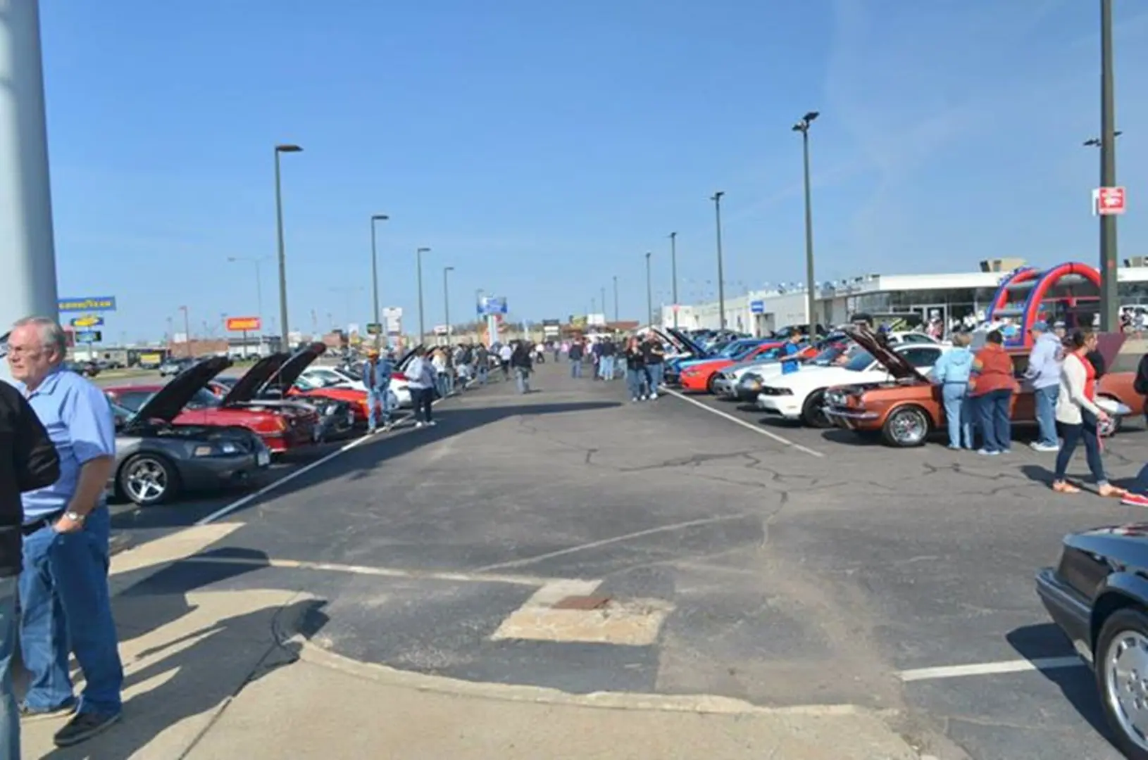 People viewing cars at a gathering