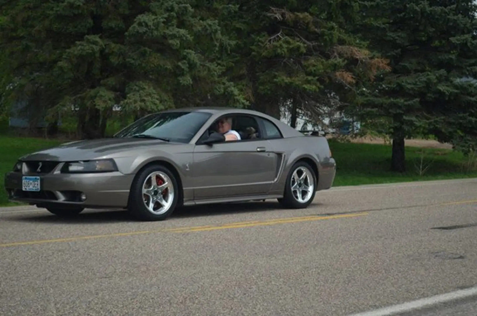 Gray sports car driving on a road