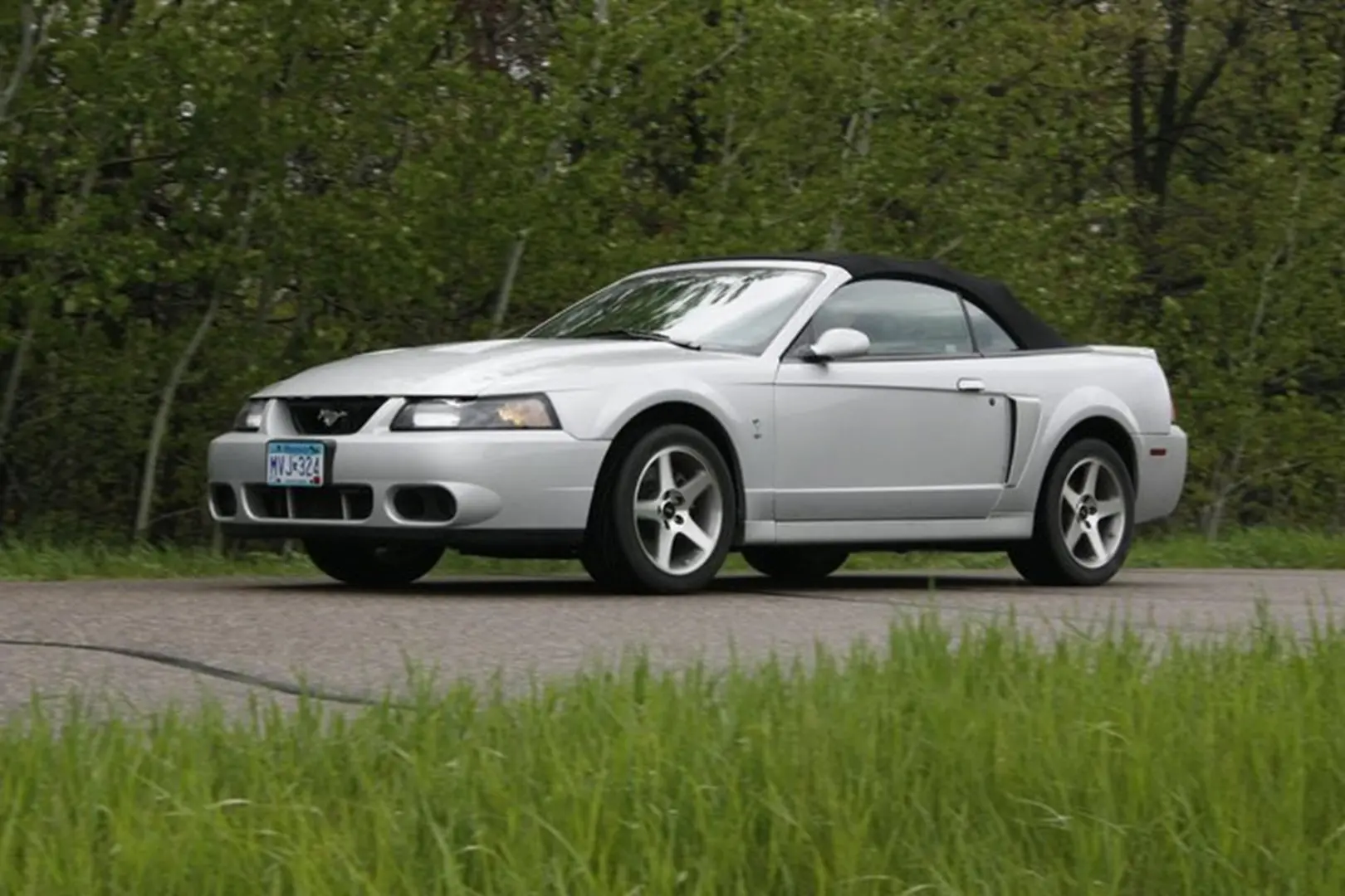 Sports car with black soft top driving