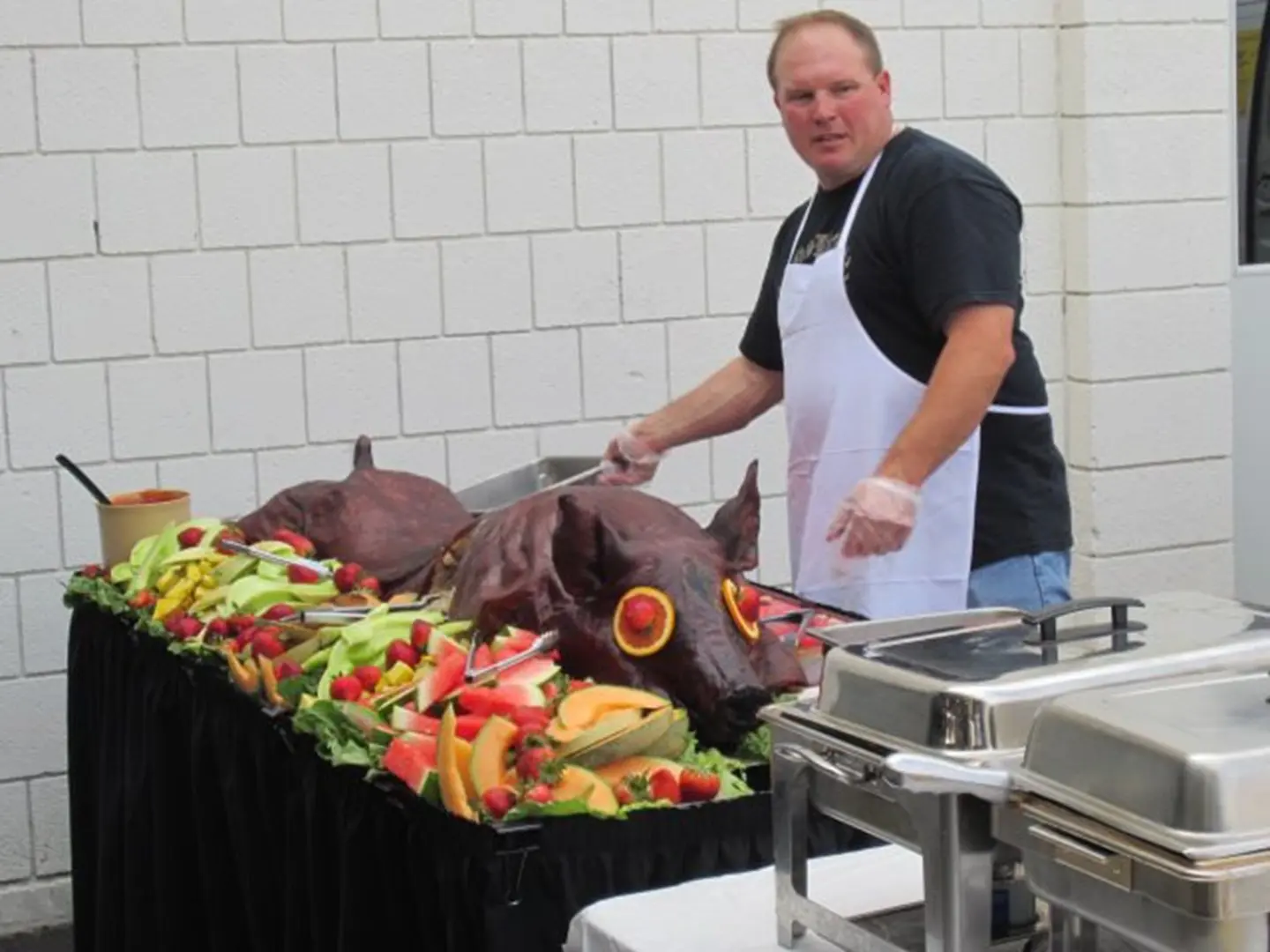 Man serving roast pig at buffet