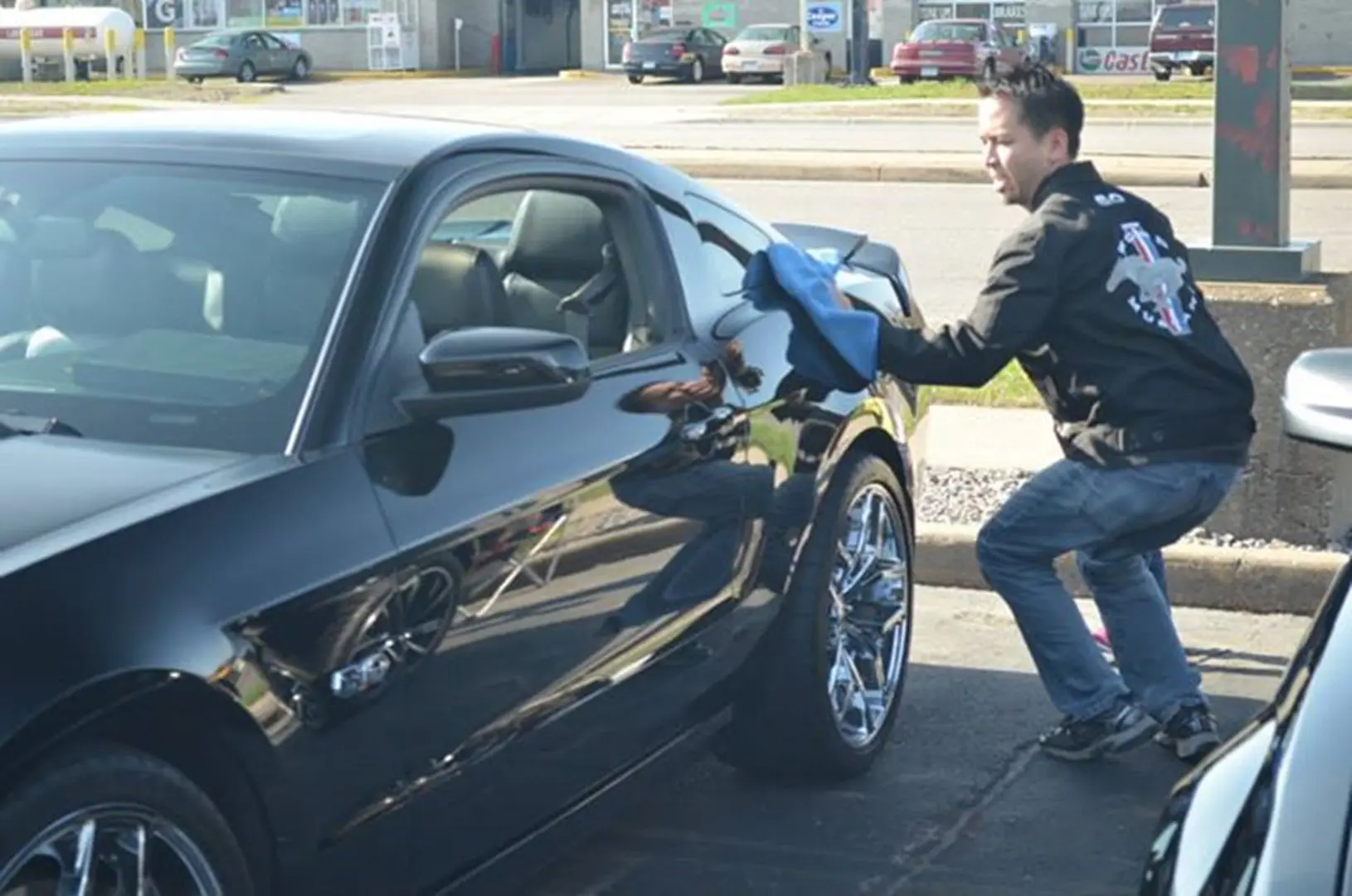 Person cleaning shiny car exterior