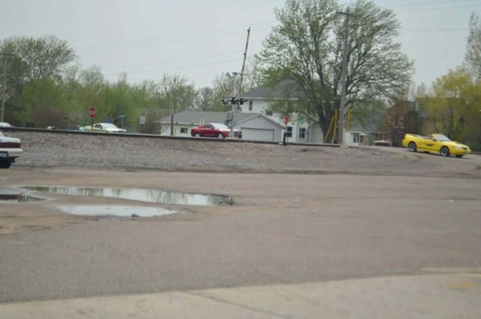 Railroad crossing with cars and trees