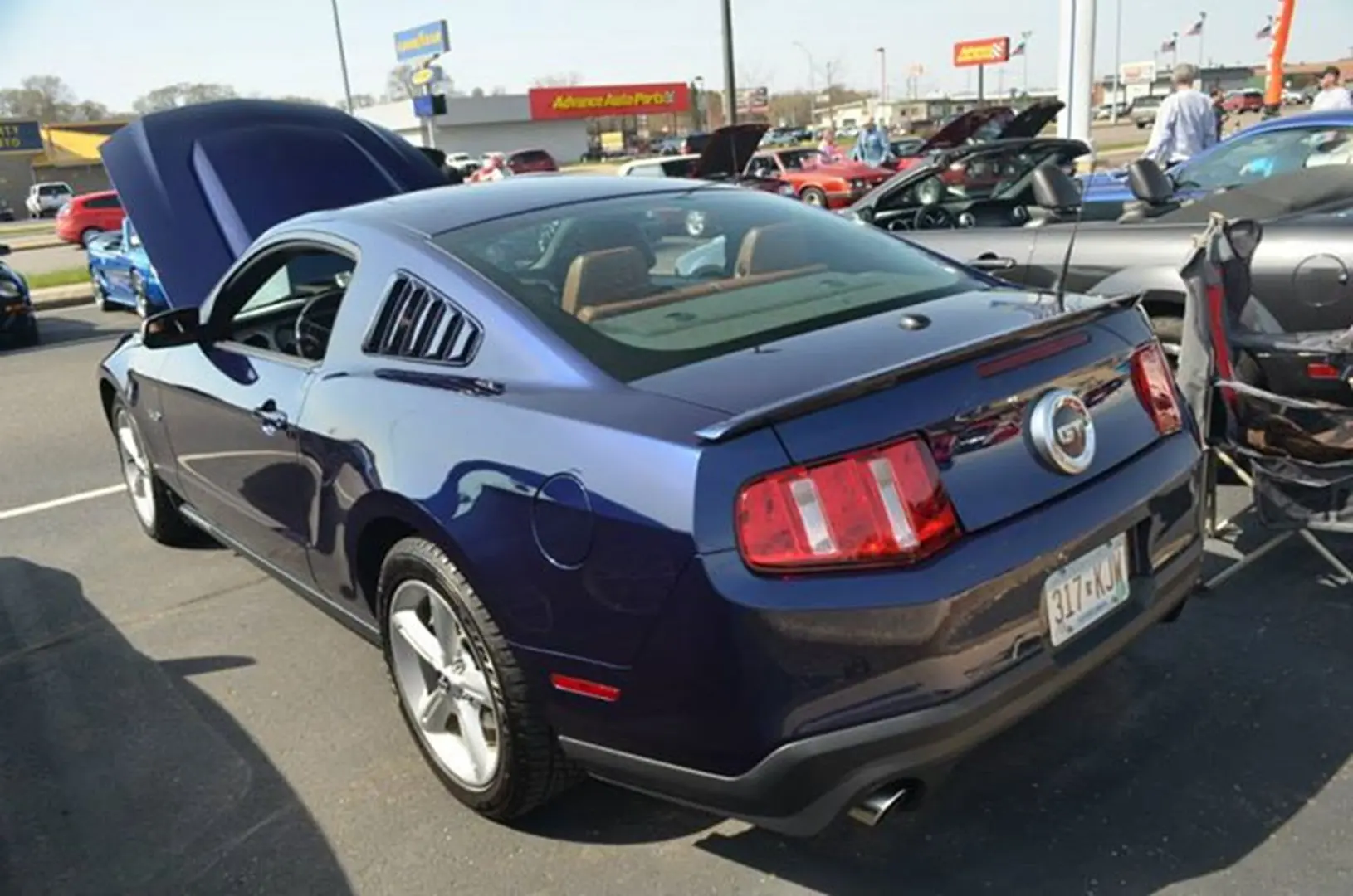Blue car with open hood at event
