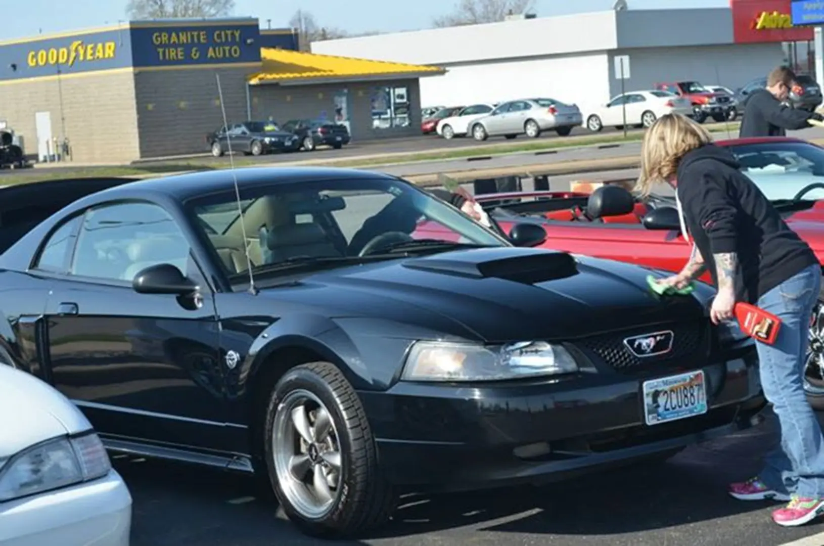 Person cleaning a black sports car