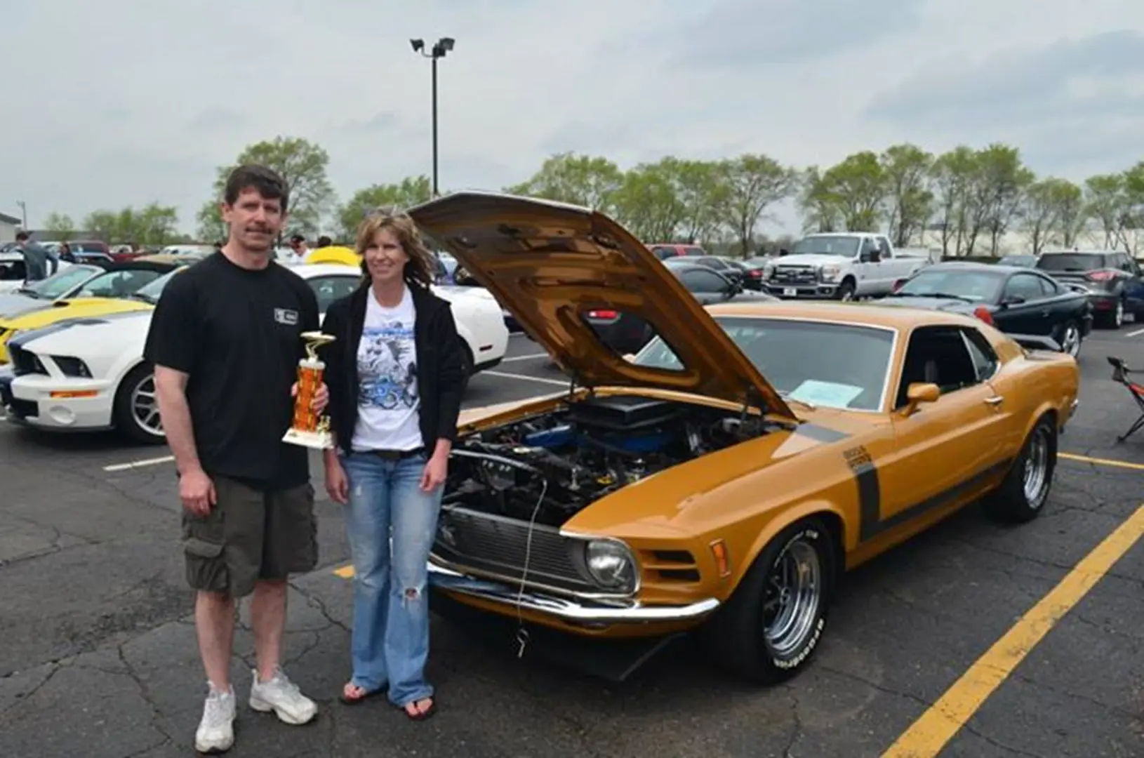 Couple with classic car and trophy