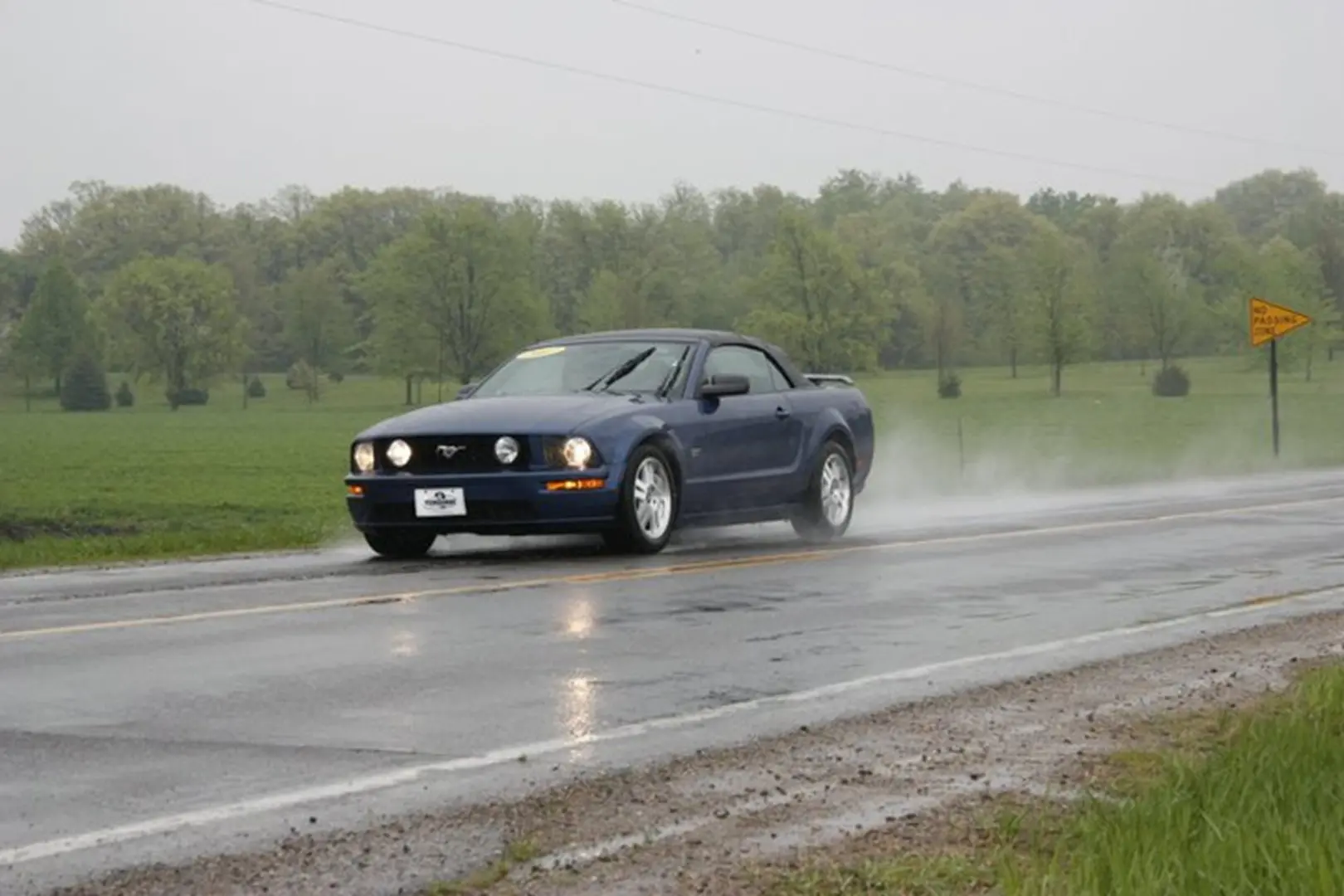 Blue car driving on wet road