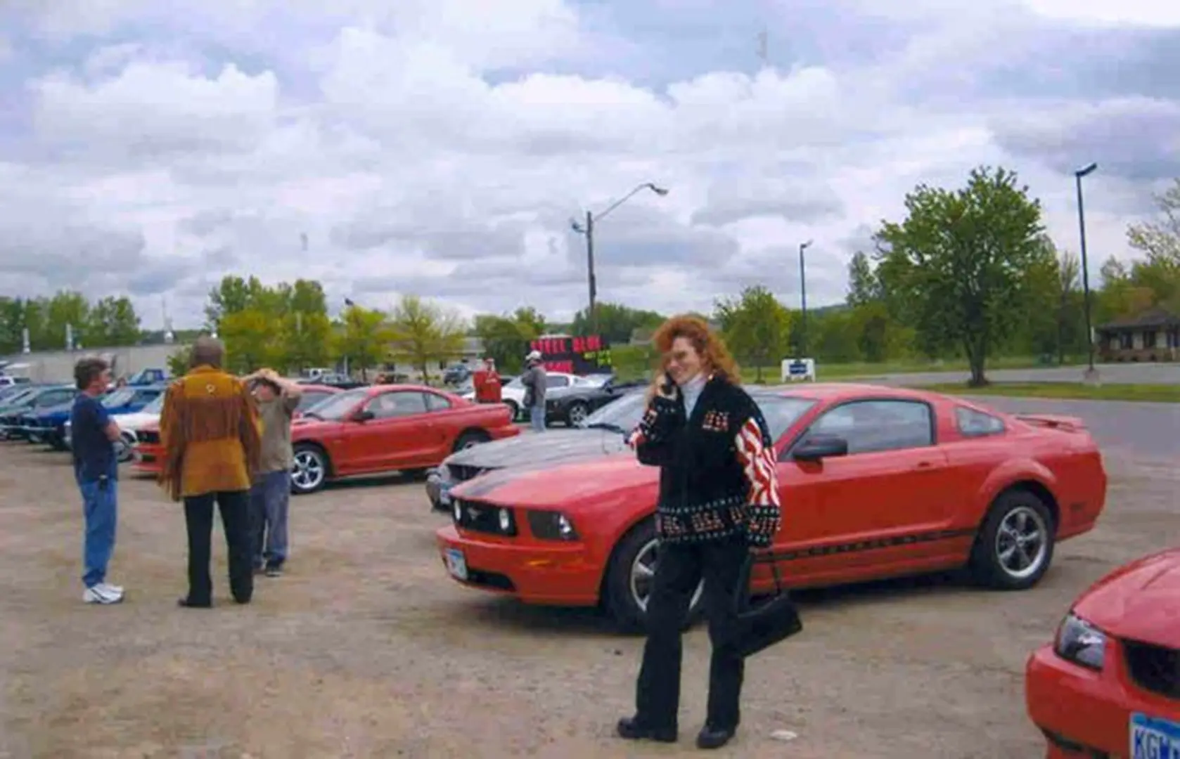 Woman standing by red sports car