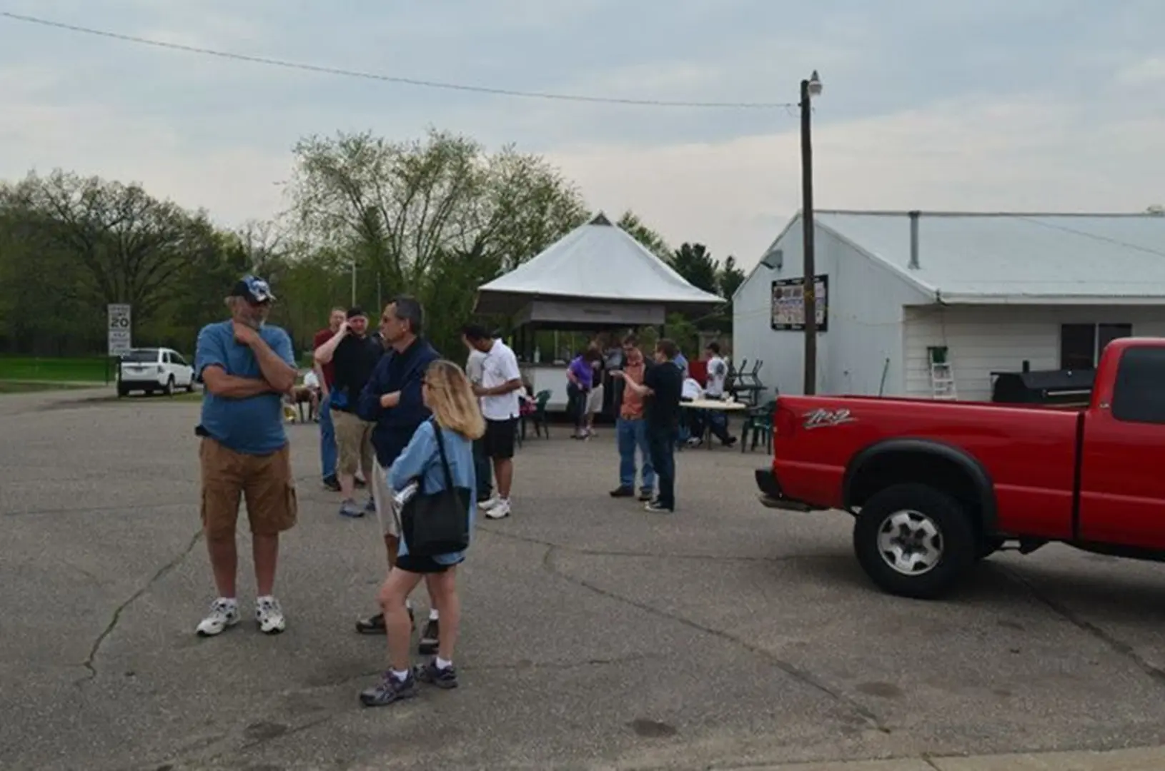 Group near red truck and white tent