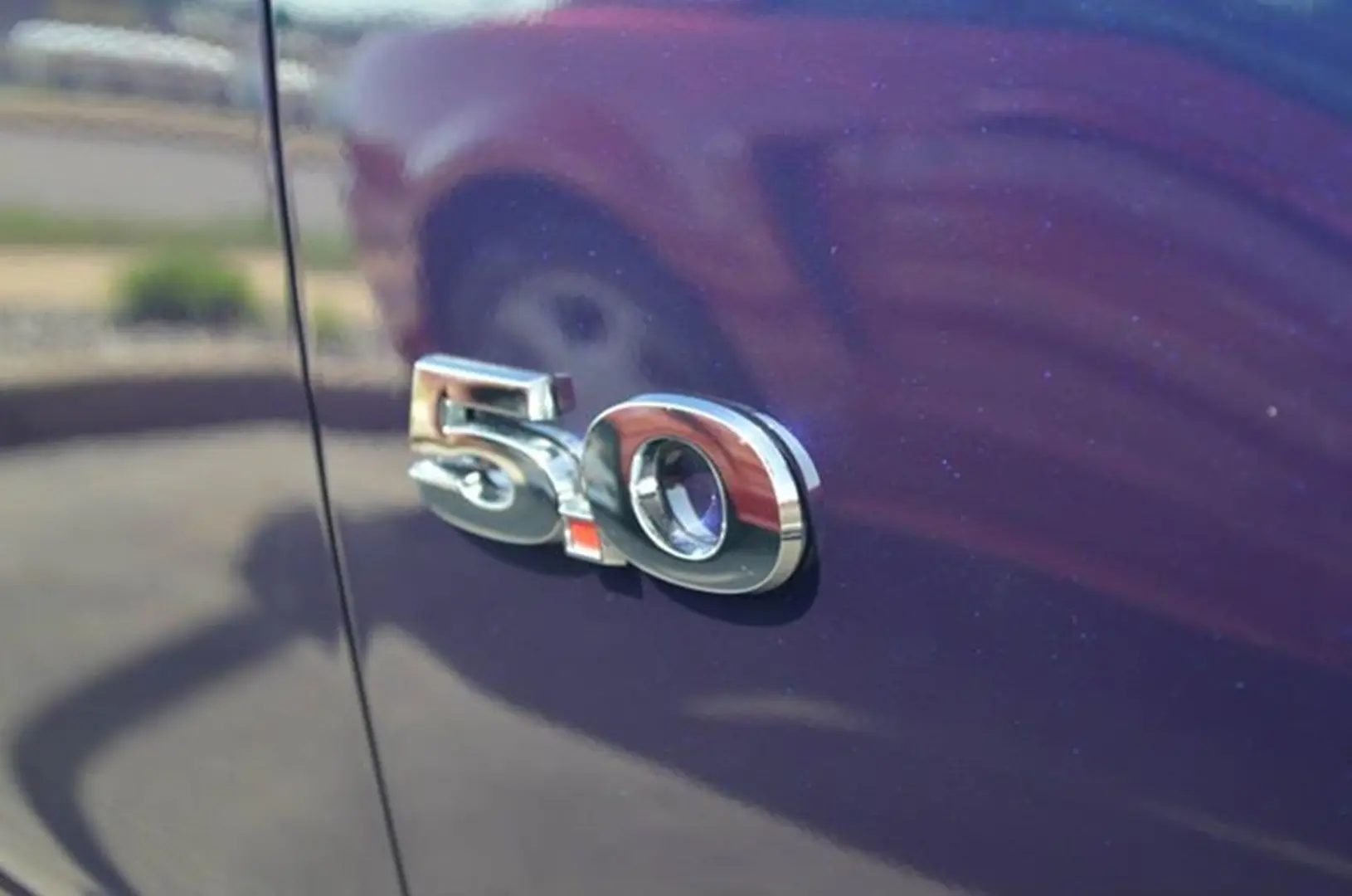 Car emblem reading 5.0 on blue surface