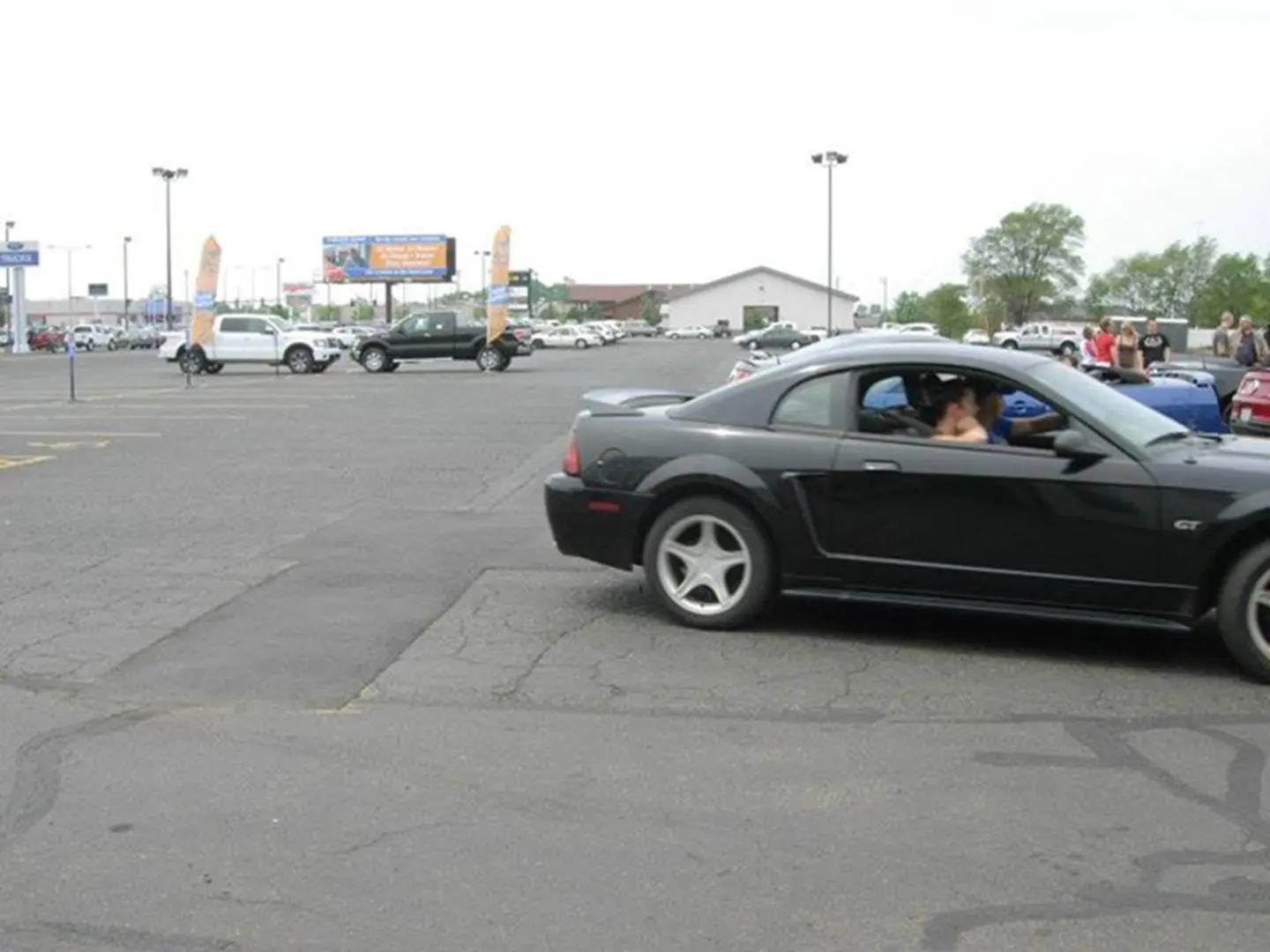 Black car turning in parking lot