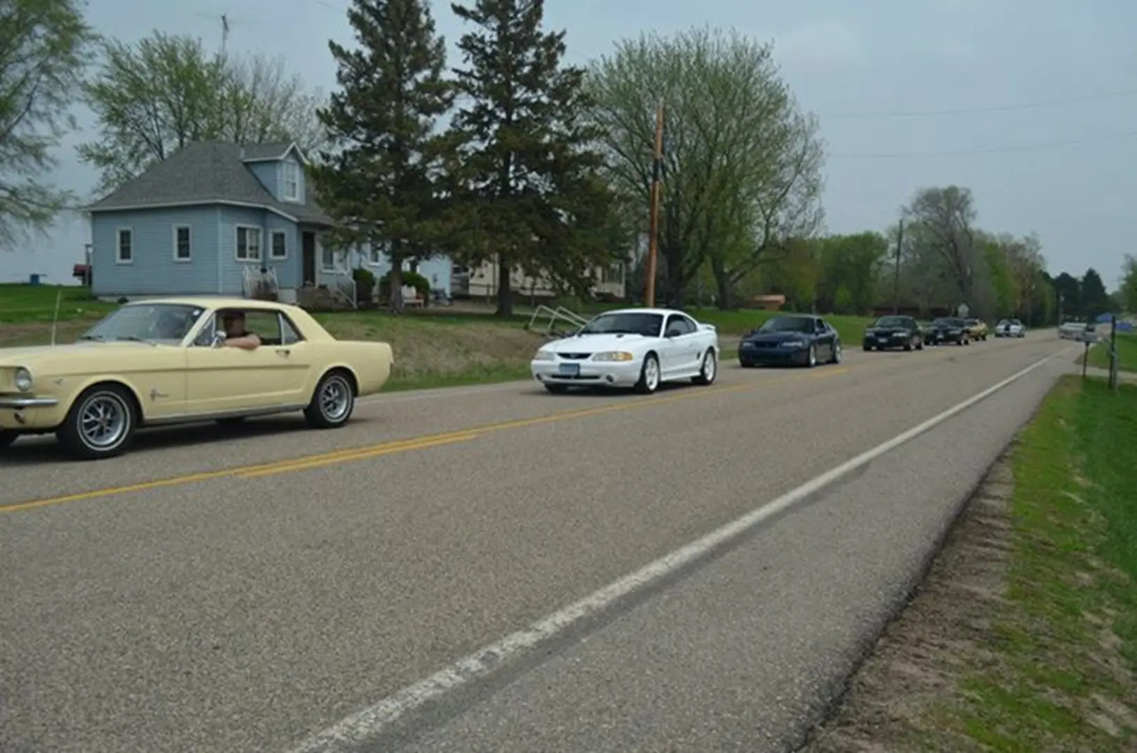Vintage cars driving on rural road