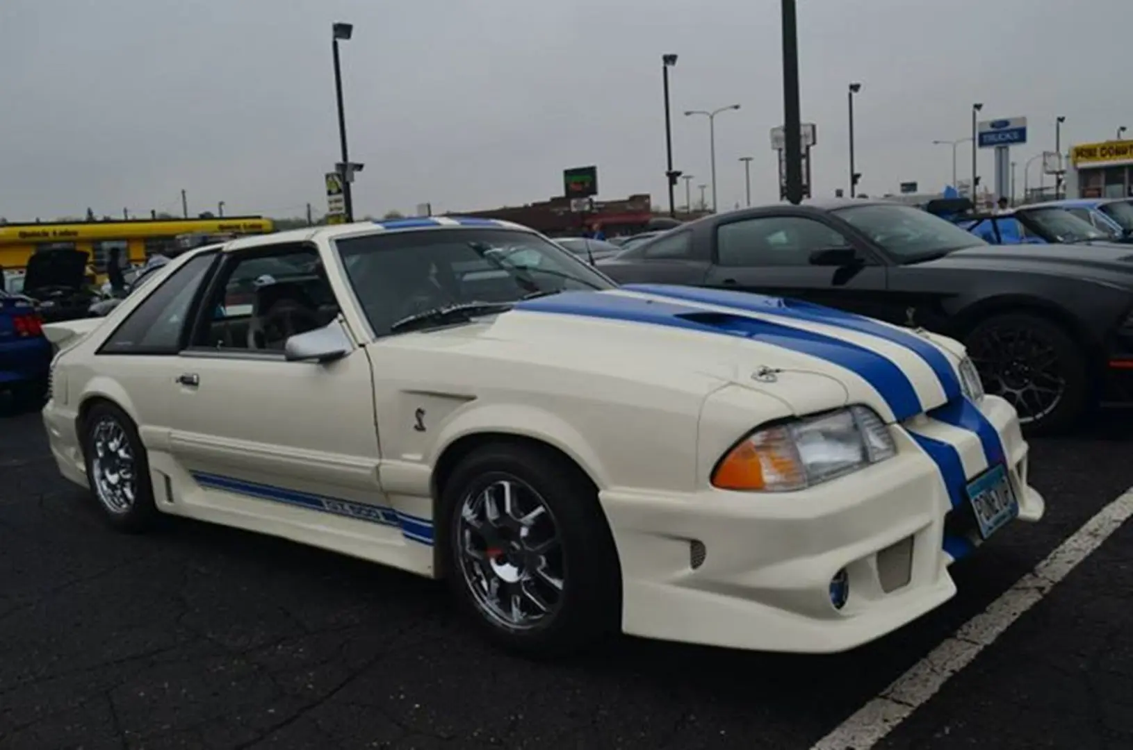 White sports car with blue racing stripes