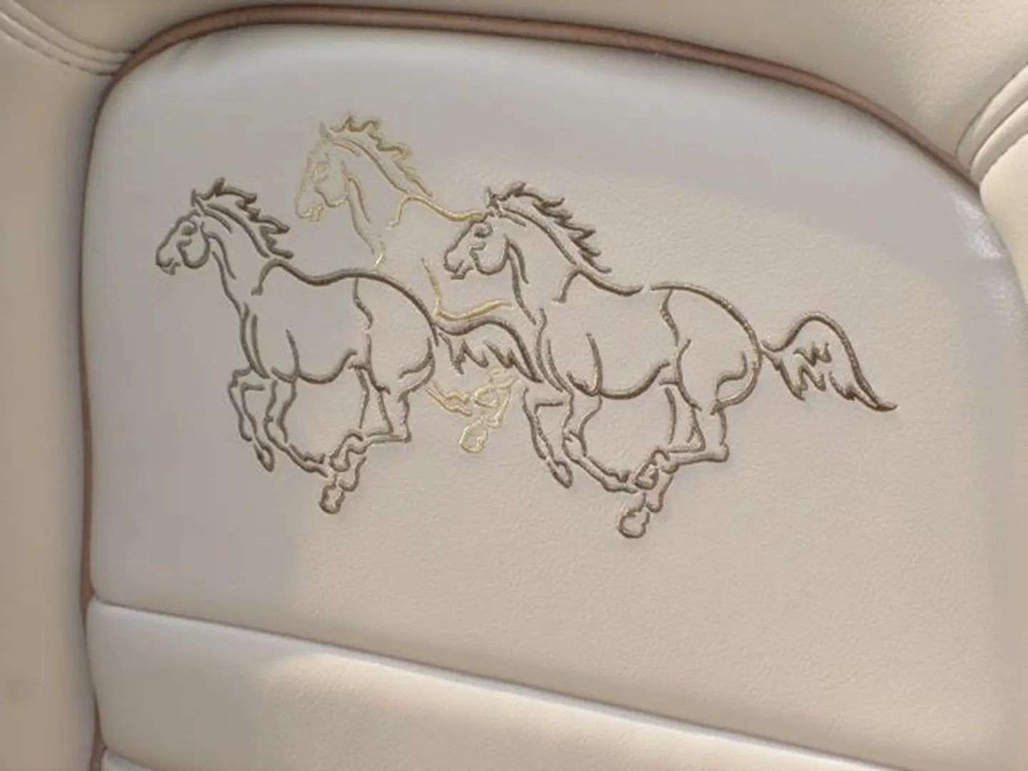 Leather seat showcasing running horse pattern