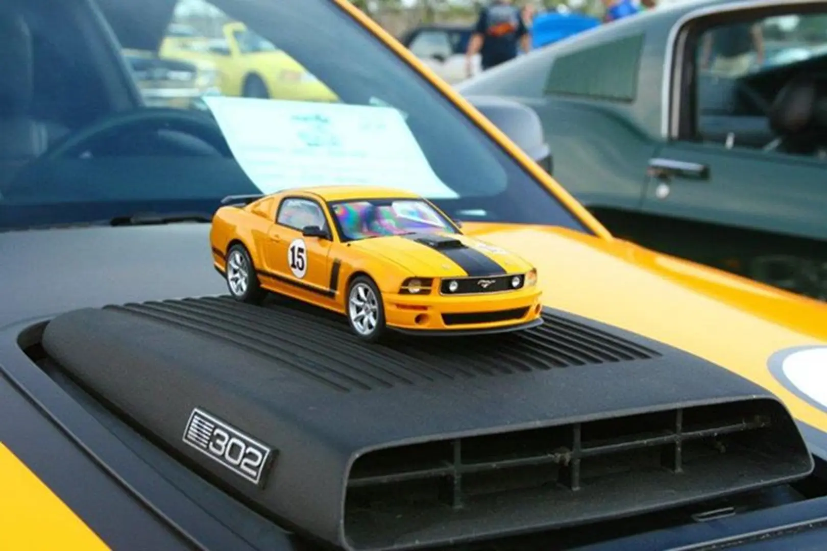 Miniature car on black hood scoop