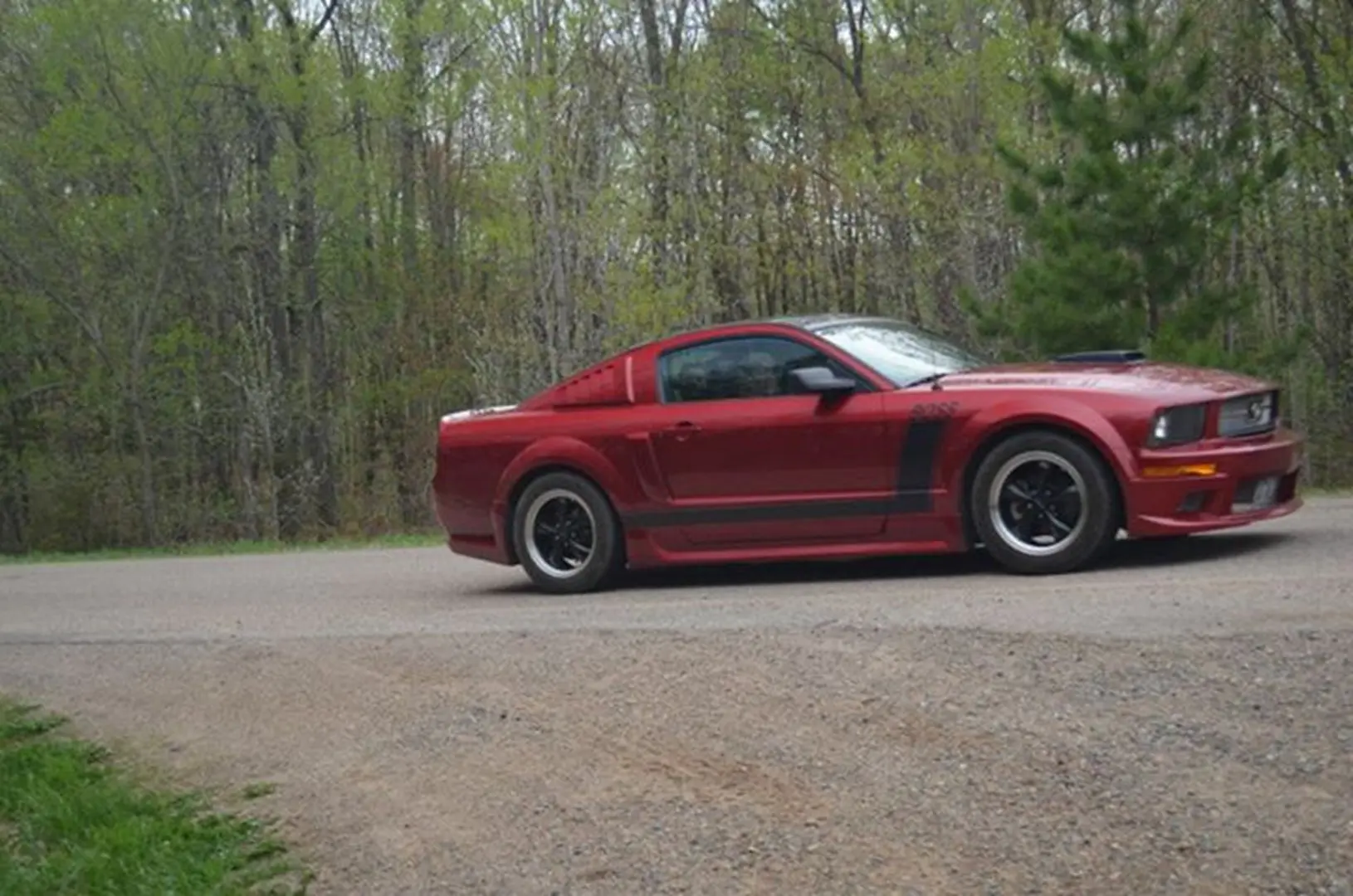 Red sports car on a forest road