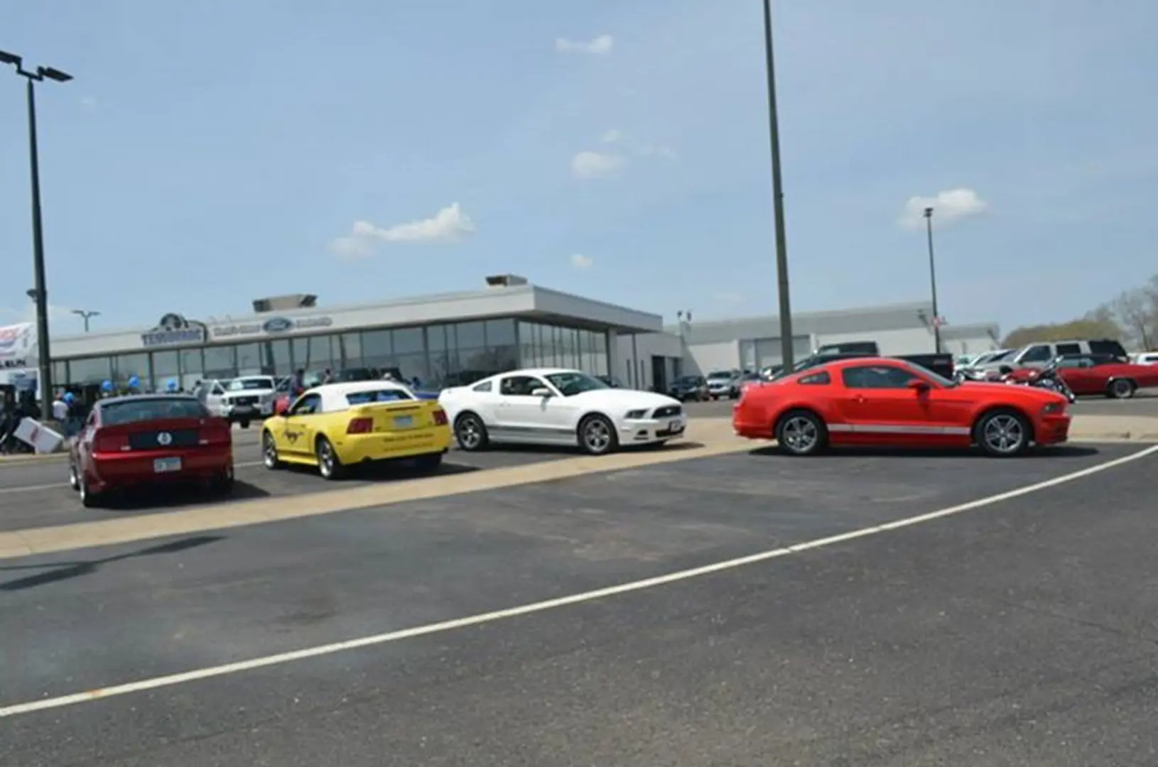 Red, yellow, white cars in parking lot