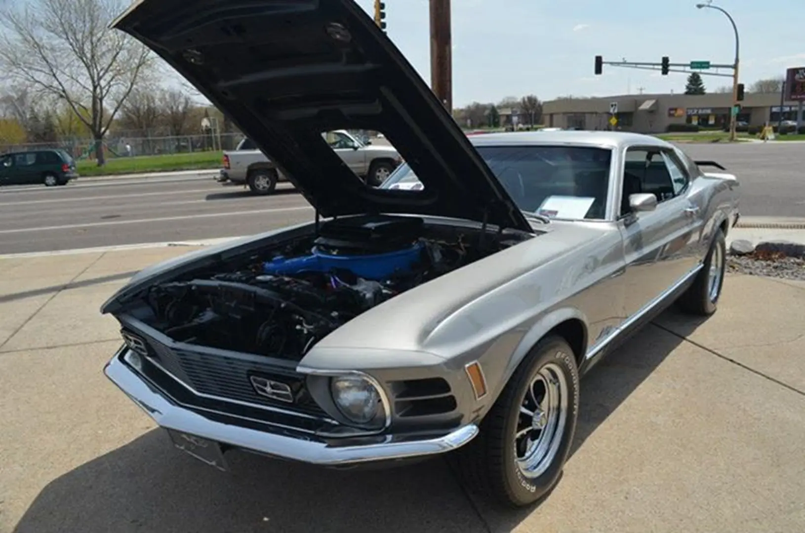 Silver car showcasing engine at intersection