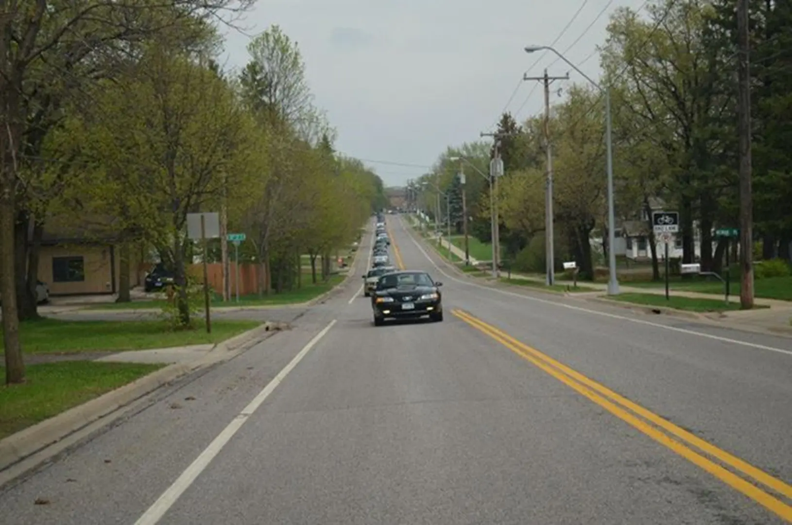 Long road with car and foliage