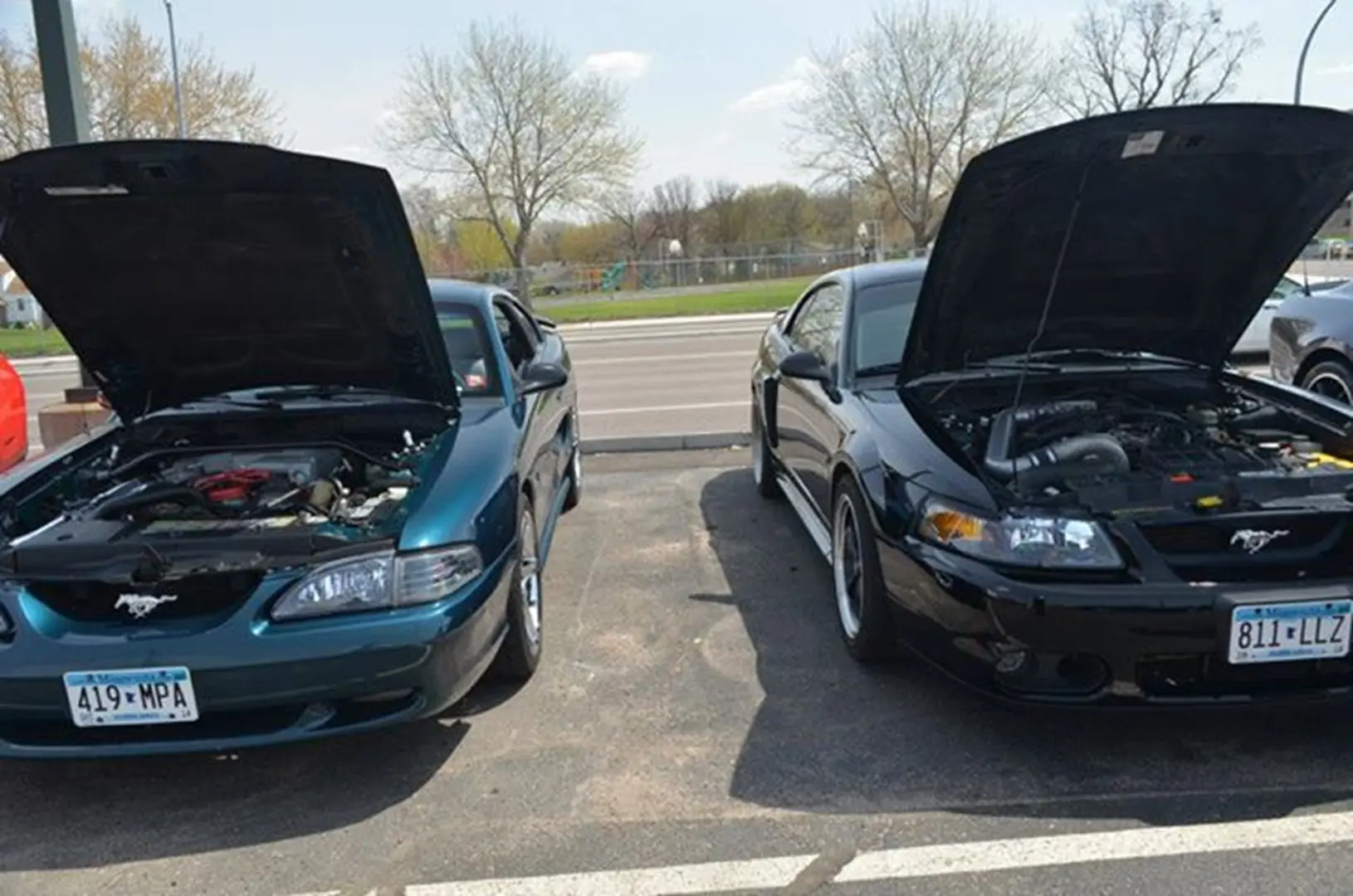 Vehicles parked with engines exposed outdoors.