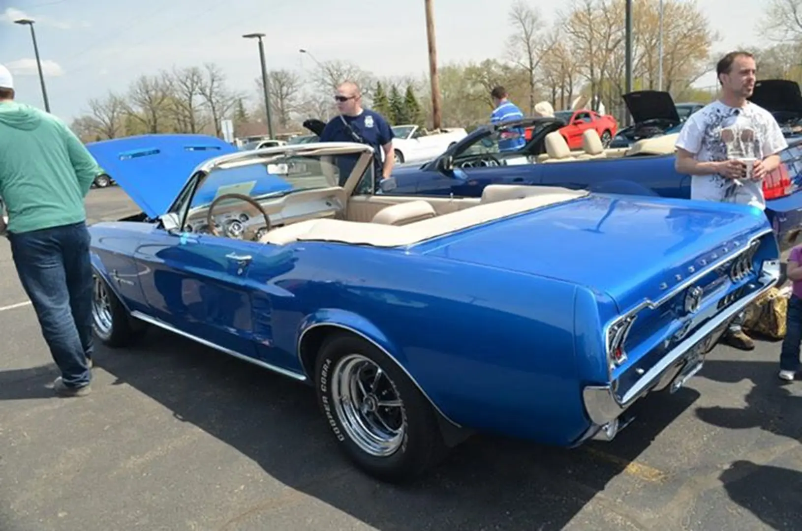 People admiring blue convertible
