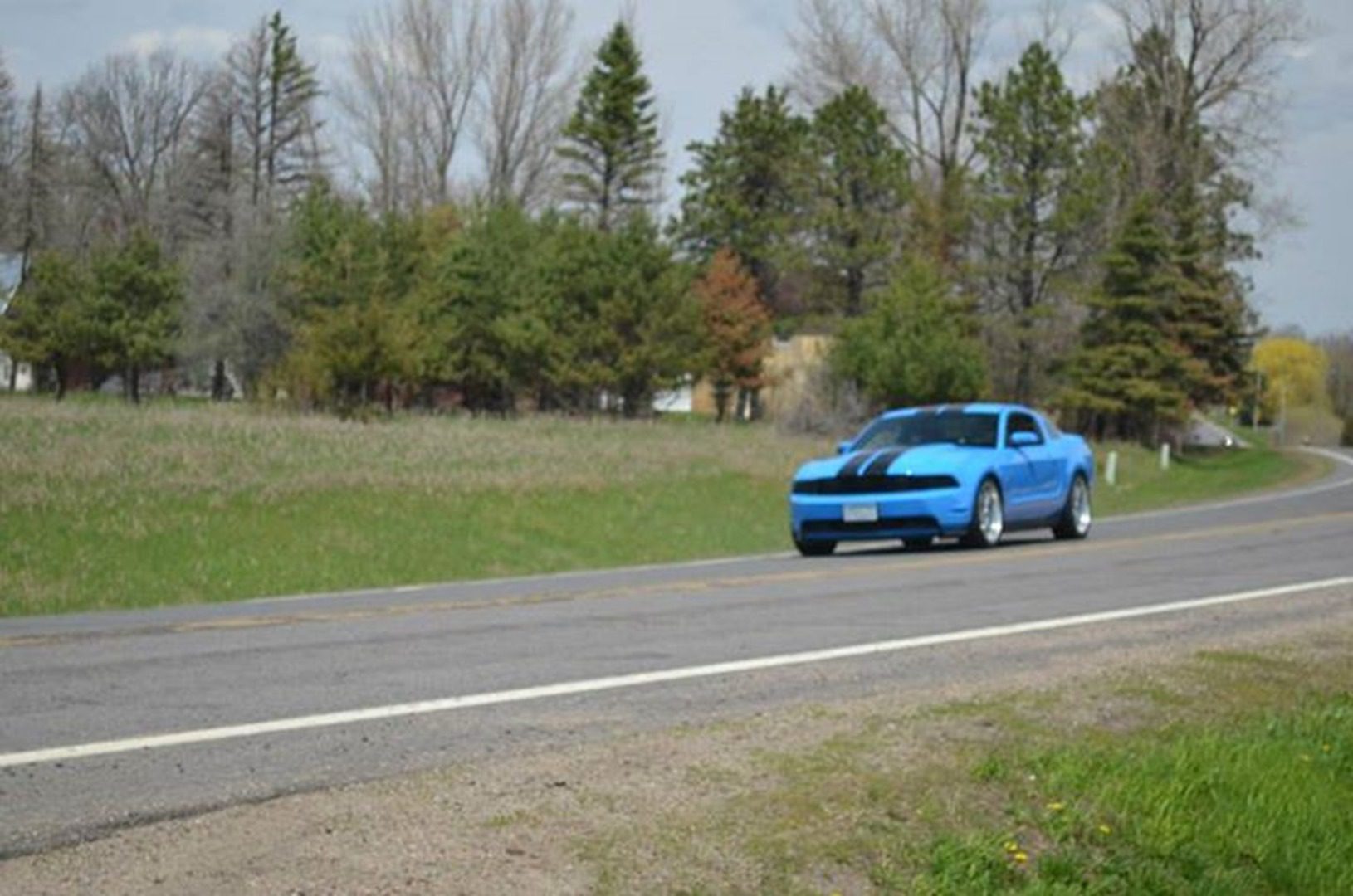 Vibrant blue car driving through countryside