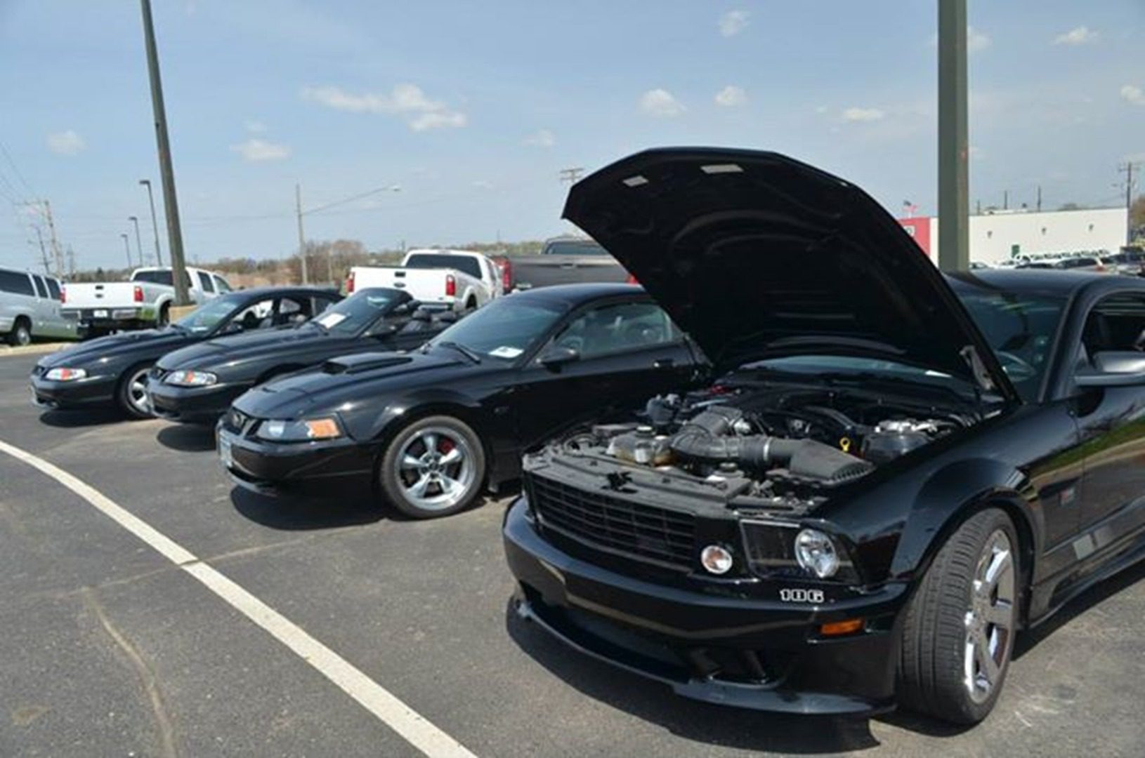 Car with hood open in parking lot