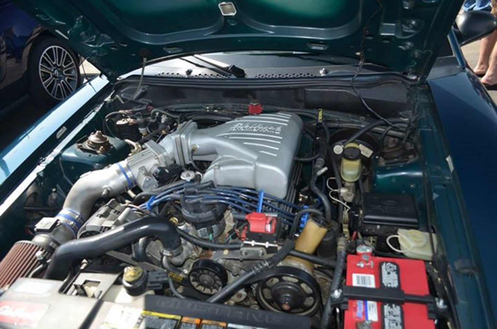 Open hood revealing engine parts