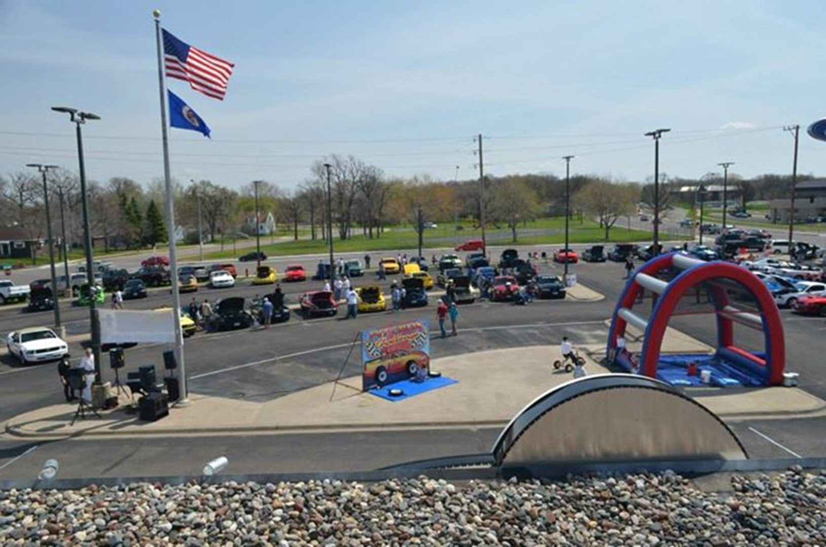 Outdoor car show with inflatable slide.