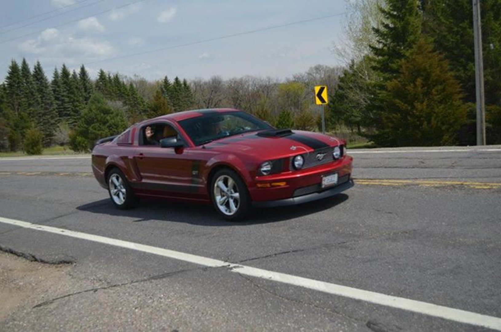 Red sports car driving on rural road