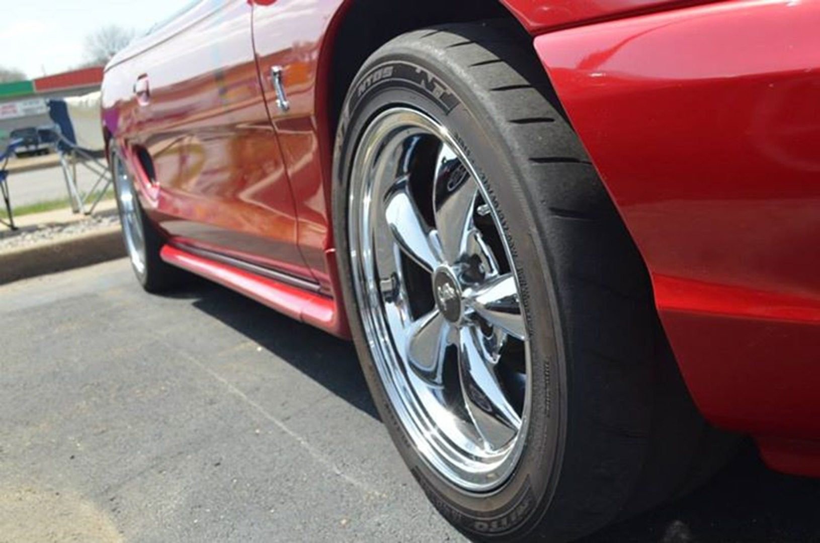 Close-up of red car's rear wheel.