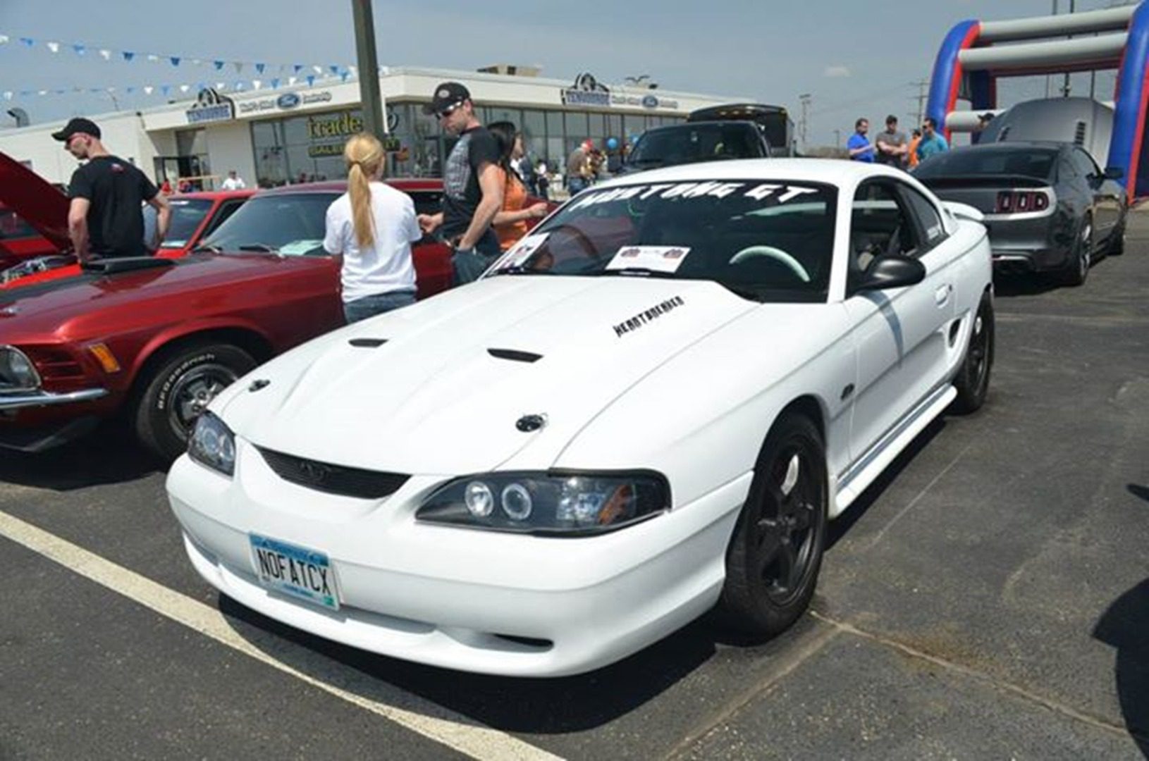 Crowded car exhibition with white vehicle