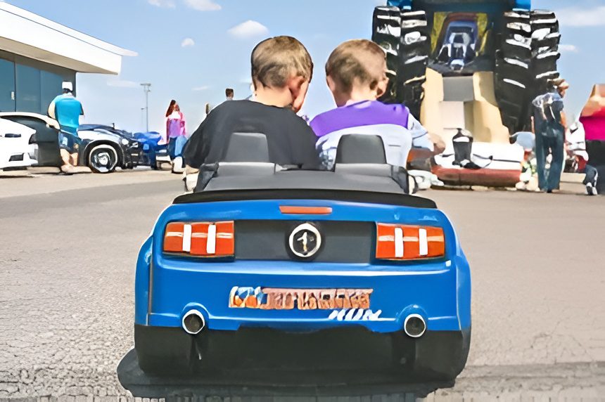 Kids in blue miniature car outdoors