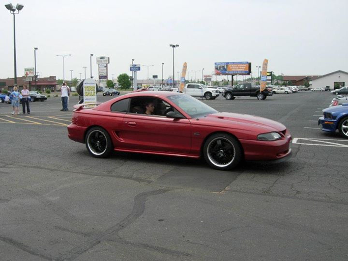 Red coupe parked in outdoor lot.